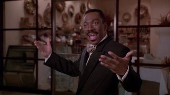 Movie still from “Boomerang” (1992), directed by Reginald Hudlin – A man wearing a suit and bow tie; Medium shot, Low angle
