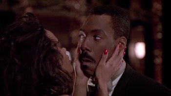 Movie still from “Boomerang” (1992), directed by Reginald Hudlin – A woman touching the face of a man with his hands on his face; Close Up shot, Low angle