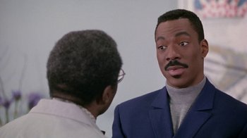 Movie still from “Boomerang” (1992), directed by Reginald Hudlin – A man in a blue suit talking to another man in a white shirt; Close Up shot, Over the shoulder angle
