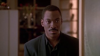 Movie still from “Boomerang” (1992), directed by Reginald Hudlin – A person wearing a suit and tie; Close Up shot, Over the shoulder angle