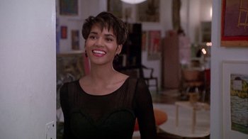 Movie still from “Boomerang” (1992), directed by Reginald Hudlin – A woman in a black dress smiling for the camera; Medium shot, Over the shoulder angle