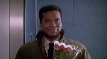 Movie still from “Boomerang” (1992), directed by Reginald Hudlin – A man holding a bouquet of flowers in his hand; Close Up shot, Over the shoulder angle