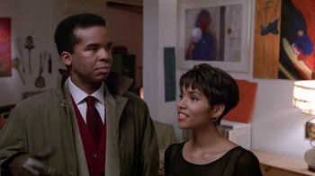 Movie still from “Boomerang” (1992), directed by Reginald Hudlin – A man and a woman standing next to each other in a room; Medium shot, Over the shoulder angle