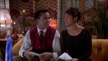 Movie still from “Boomerang” (1992), directed by Reginald Hudlin – A man and a woman sitting next to each other at a table; Medium shot, Over the shoulder angle