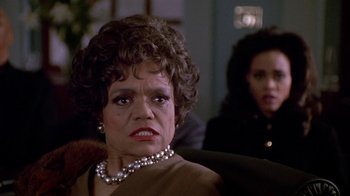 Movie still from “Boomerang” (1992), directed by Reginald Hudlin – An older woman wearing a pearl necklace and a brown jacket; Close Up shot, Low angle