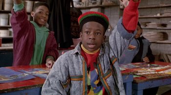 Movie still from “Boomerang” (1992), directed by Reginald Hudlin – A young boy wearing a hat and a jacket; Medium shot, High angle