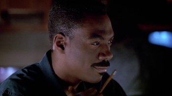 Movie still from “Boomerang” (1992), directed by Reginald Hudlin – A person holding a pencil in his mouth; Close Up shot, High angle