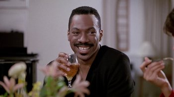 Movie still from “Boomerang” (1992), directed by Reginald Hudlin – A man holding a glass of beer in his hand; Close Up shot, Low angle