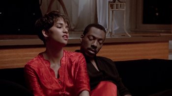 Movie still from “Boomerang” (1992), directed by Reginald Hudlin – A man and a woman sitting next to each other on a couch; Medium shot, High angle