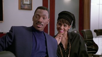 Movie still from “Boomerang” (1992), directed by Reginald Hudlin – A man and a woman pose for a picture; Medium shot, Over the shoulder angle