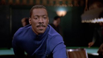 Movie still from “Boomerang” (1992), directed by Reginald Hudlin – A man sitting in front of a table in a restaurant; Close Up shot, Over the shoulder angle