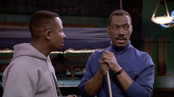 Movie still from “Boomerang” (1992), directed by Reginald Hudlin – Two men standing next to each other holding a pool stick; Close Up shot, Over the shoulder angle