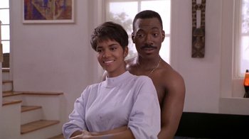 Movie still from “Boomerang” (1992), directed by Reginald Hudlin – A man and a woman posing for a picture; Medium shot, Low angle
