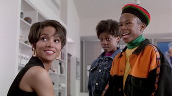 Movie still from “Boomerang” (1992), directed by Reginald Hudlin – A woman and two young boys standing next to each other in a room; Close Up shot, Over the shoulder angle