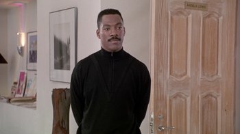 Movie still from “Boomerang” (1992), directed by Reginald Hudlin – A man standing in front of a door wearing a black shirt; Medium shot, Over the shoulder angle