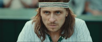 Movie still from “Borg vs. McEnroe” (2017), directed by Janus Metz – A person with long hair wearing a headband; Close Up shot, Low angle