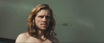 Movie still from “Borg vs. McEnroe” (2017), directed by Janus Metz – A man with long brown hair and a beard; Close Up shot, Low angle
