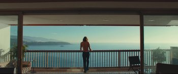 Movie still from “Borg vs. McEnroe” (2017), directed by Janus Metz – A man standing on a balcony looking out at the ocean; Wide shot, Low angle