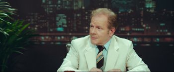 Movie still from “Borg vs. McEnroe” (2017), directed by Janus Metz – A man wearing a white suit and a tie; Medium shot, Over the shoulder angle