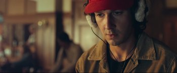 Movie still from “Borg vs. McEnroe” (2017), directed by Janus Metz – A person wearing headphones and a red hat; Close Up shot, Over the shoulder angle