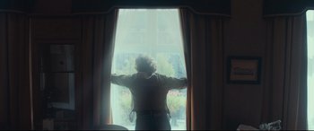 Movie still from “Borg vs. McEnroe” (2017), directed by Janus Metz – A woman standing in front of a window looking outside; Medium shot, Low angle