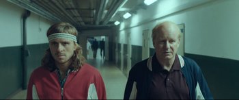 Movie still from “Borg vs. McEnroe” (2017), directed by Janus Metz – A man and a woman walking down a hall way; Medium shot, Over the shoulder angle