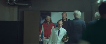 Movie still from “Borg vs. McEnroe” (2017), directed by Janus Metz – A group of men standing next to each other in a room; Wide shot, Low angle