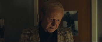 Movie still from “Borg vs. McEnroe” (2017), directed by Janus Metz – An older man with blonde hair wearing a plaid jacket; Close Up shot, Over the shoulder angle