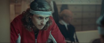 Movie still from “Borg vs. McEnroe” (2017), directed by Janus Metz – A person with long hair wearing a headband; Close Up shot, Over the shoulder angle