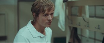 Movie still from “Borg vs. McEnroe” (2017), directed by Janus Metz – A man in a white shirt is looking at the camera; Close Up shot, Over the shoulder angle