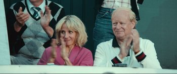 Movie still from “Borg vs. McEnroe” (2017), directed by Janus Metz – A woman and a man sitting next to each other at an event; Medium shot, Over the shoulder angle