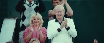 Movie still from “Borg vs. McEnroe” (2017), directed by Janus Metz – A man and a woman clapping at a sporting event; Medium shot, High angle