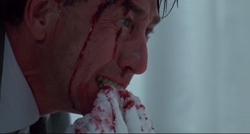 Movie still from “Bound” (1996), directed by Lilly Wachowski – A person with blood on his face; Extreme Close Up shot, Low angle
