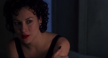 Movie still from “Bound” (1996), directed by Lilly Wachowski – A woman with red lipstick sitting in front of a window; Close Up shot, High angle