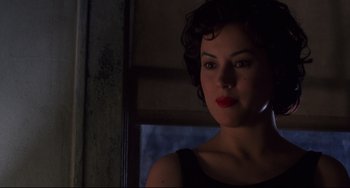 Movie still from “Bound” (1996), directed by Lilly Wachowski – A woman with red lipstick is standing in a dark room; Close Up shot, Low angle