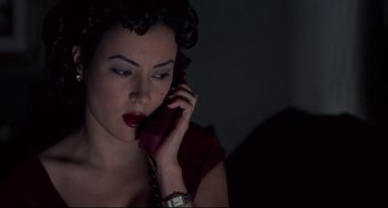 Movie still from “Bound” (1996), directed by Lilly Wachowski – A woman is talking on a cell phone in the dark; Close Up shot, High angle