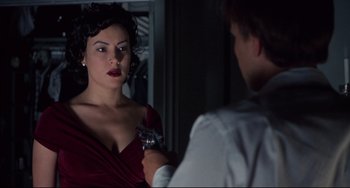 Movie still from “Bound” (1996), directed by Lilly Wachowski – A woman in a red dress is holding a gun; Close Up shot, Over the shoulder angle