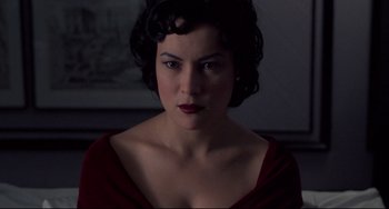 Movie still from “Bound” (1996), directed by Lilly Wachowski – A woman with dark hair and a red dress; Close Up shot, Over the shoulder angle
