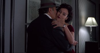 Movie still from “Bound” (1996), directed by Lilly Wachowski – A man and a woman kissing in a room; Medium shot, Over the shoulder angle