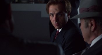 Movie still from “Bound” (1996), directed by Lilly Wachowski – A man sitting in front of a computer in a dark room; Close Up shot, Low angle