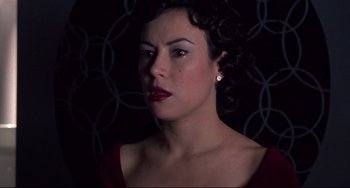 Movie still from “Bound” (1996), directed by Lilly Wachowski – A woman in a red dress is looking at the camera; Close Up shot, Low angle