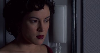 Movie still from “Bound” (1996), directed by Lilly Wachowski – A person wearing a red shirt near a phone; Close Up shot, Low angle