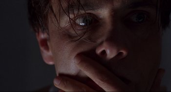 Movie still from “Bound” (1996), directed by Lilly Wachowski – A man's face with his hand over his mouth; Extreme Close Up shot, Low angle