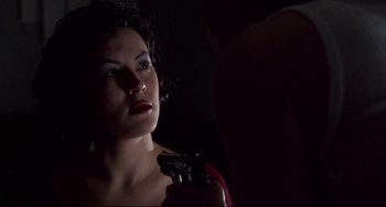 Movie still from “Bound” (1996), directed by Lilly Wachowski – A woman is holding a gun in her hand; Close Up shot, Over the shoulder angle