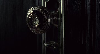 Movie still from “Bound” (1996), directed by Lilly Wachowski – View of a door knob on a black door; Extreme Close Up shot, High angle