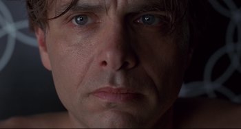 Movie still from “Bound” (1996), directed by Lilly Wachowski – A man's face with blue eyes; Extreme Close Up shot, Low angle