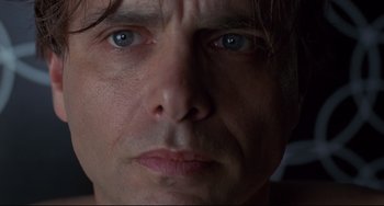 Movie still from “Bound” (1996), directed by Lilly Wachowski – A man's face with blue eyes; Extreme Close Up shot, Low angle