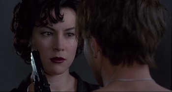 Movie still from “Bound” (1996), directed by Lilly Wachowski – A woman looking at a man in a mirror; Close Up shot, Over the shoulder angle