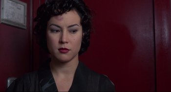 Movie still from “Bound” (1996), directed by Lilly Wachowski – A person wearing a black shirt; Close Up shot, Over the shoulder angle