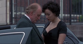Movie still from “Bound” (1996), directed by Lilly Wachowski – A man and a woman standing next to each other in front of a car; Medium shot, Low angle